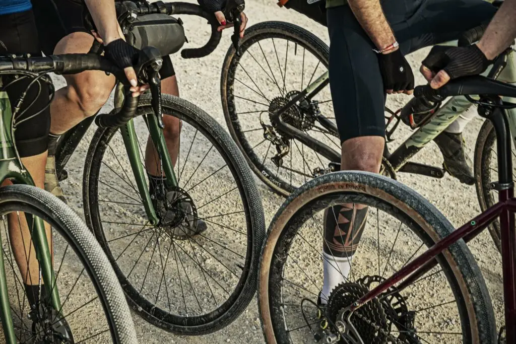 Dettaglio di ruote di biciclette gravel durante un'avventura di bikepacking su strade sterrate.
