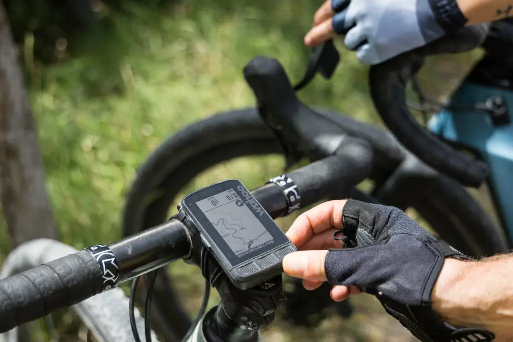 Ciclista che utilizza un navigatore GPS su una bicicletta durante un'uscita di bikepacking.